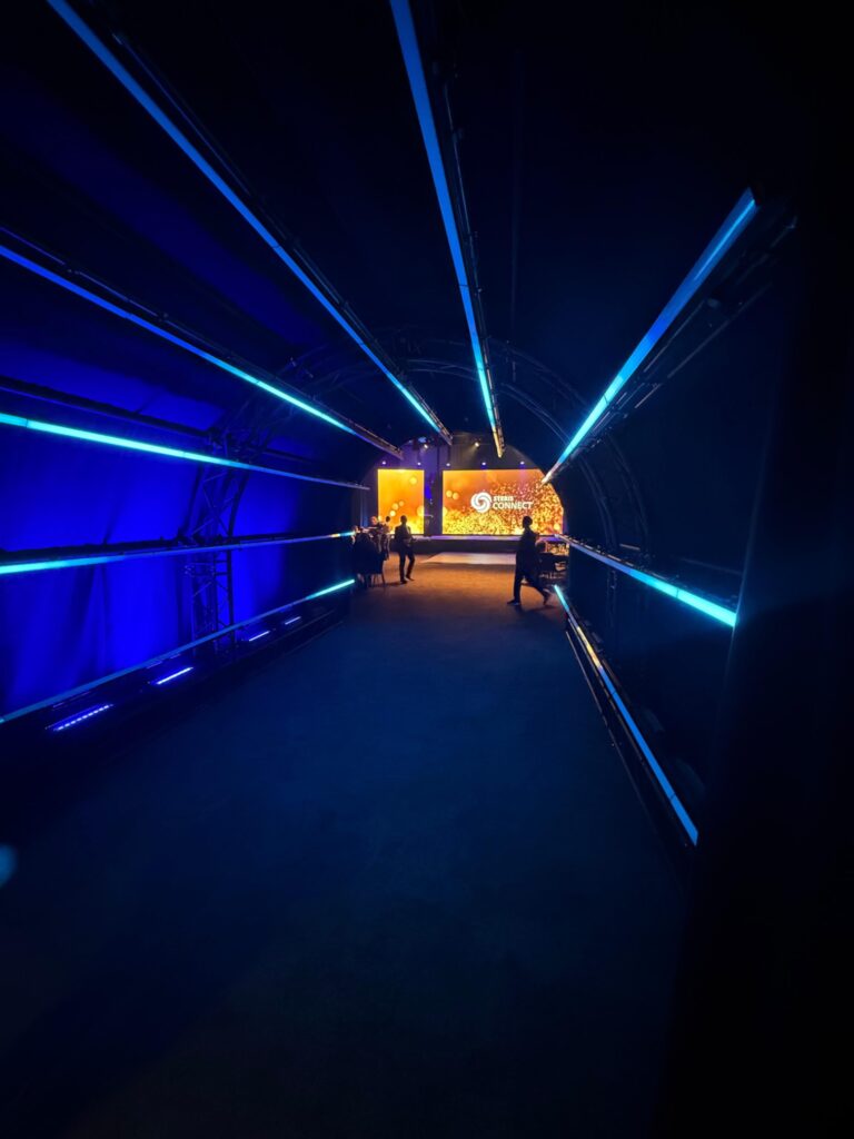 Blauwe lichtlijnen en podiumverlichting bij een corporate evenement