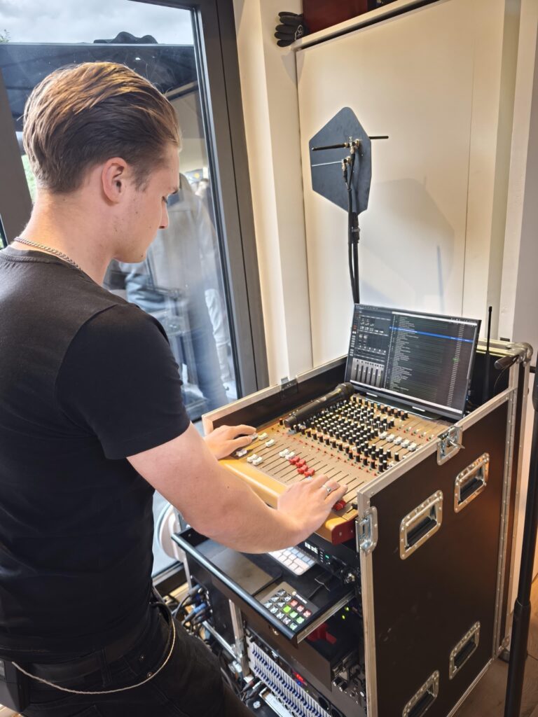 Geluidstechnicus van Muller Productions tijdens het afstellen en monitoren van evenementengeluid