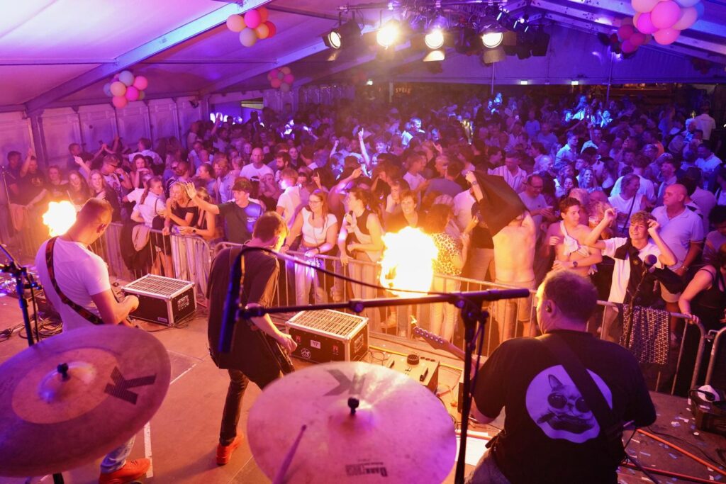 Phoenix Coverband op het podium voor een volle feesttent