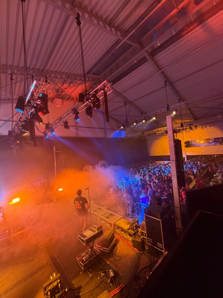 Podium met truss en showverlichting tijdens een druk bezocht live evenement